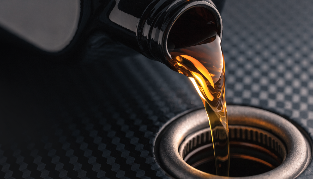 Golden ester oil pouring into an engine filler neck