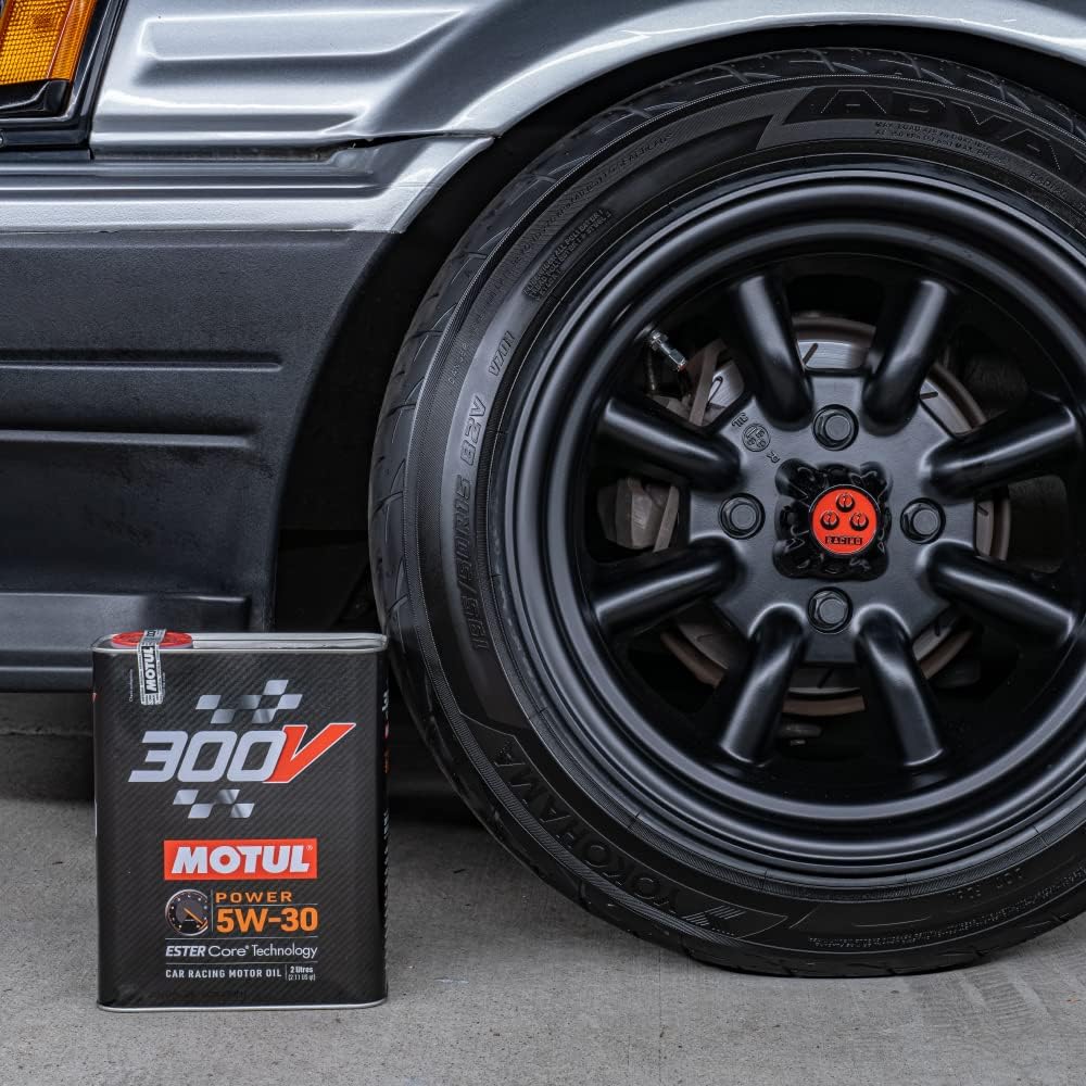 Motul 300V Power 5W-30 2L beside a performance-car wheel